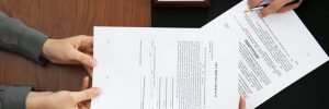woman passing legal documents to attorney