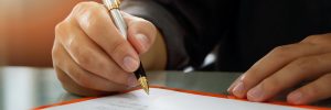 man signing legal document