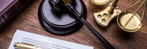 Wooden Gavel Golden Scale And Law Book On Table