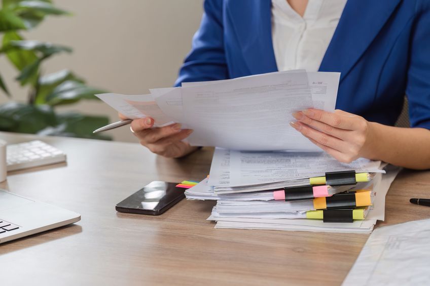 Woman reviewing court documents at a desk, preparing for filing.
