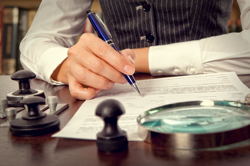 Woman notary, lawyer signs the documents in office